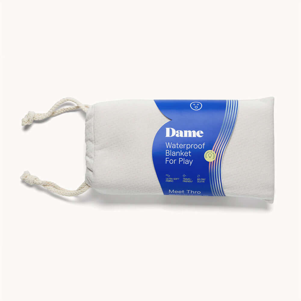 Dame Thro Waterproof Sex Blanket Oat packaged with drawstring for easy storage and use during intimate moments.