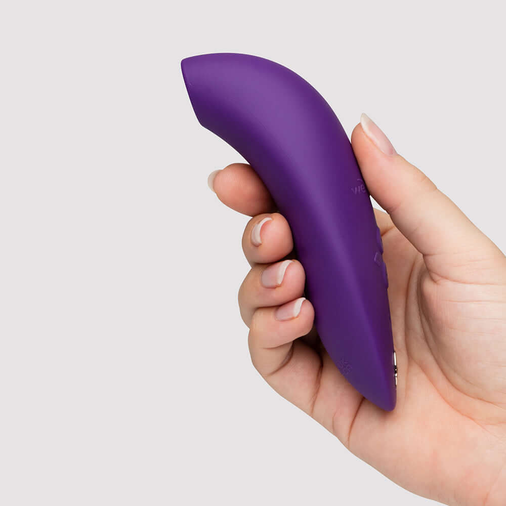 We-Vibe Melt 2 Pleasure Air Clitoral Stimulator Purple held in a woman's hand, showcasing ergonomic design for intimacy.