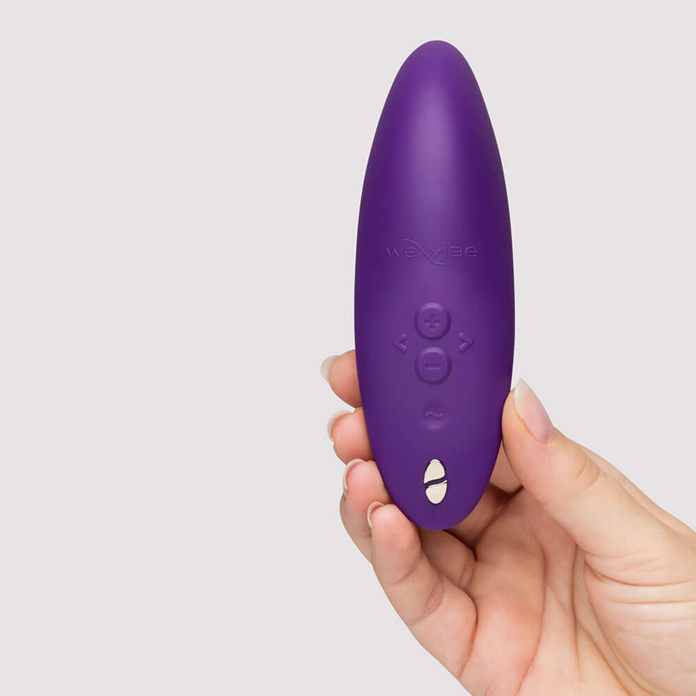 We-Vibe Melt 2 Pleasure Air Clitoral Stimulator Purple held in hand with buttons visible.