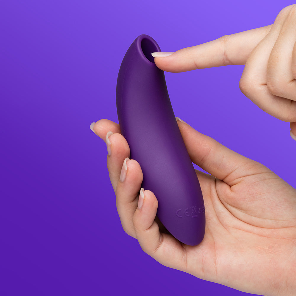We-Vibe Melt 2 Pleasure Air Clitoral Stimulator Purple held in hand, showcasing its ergonomic design.