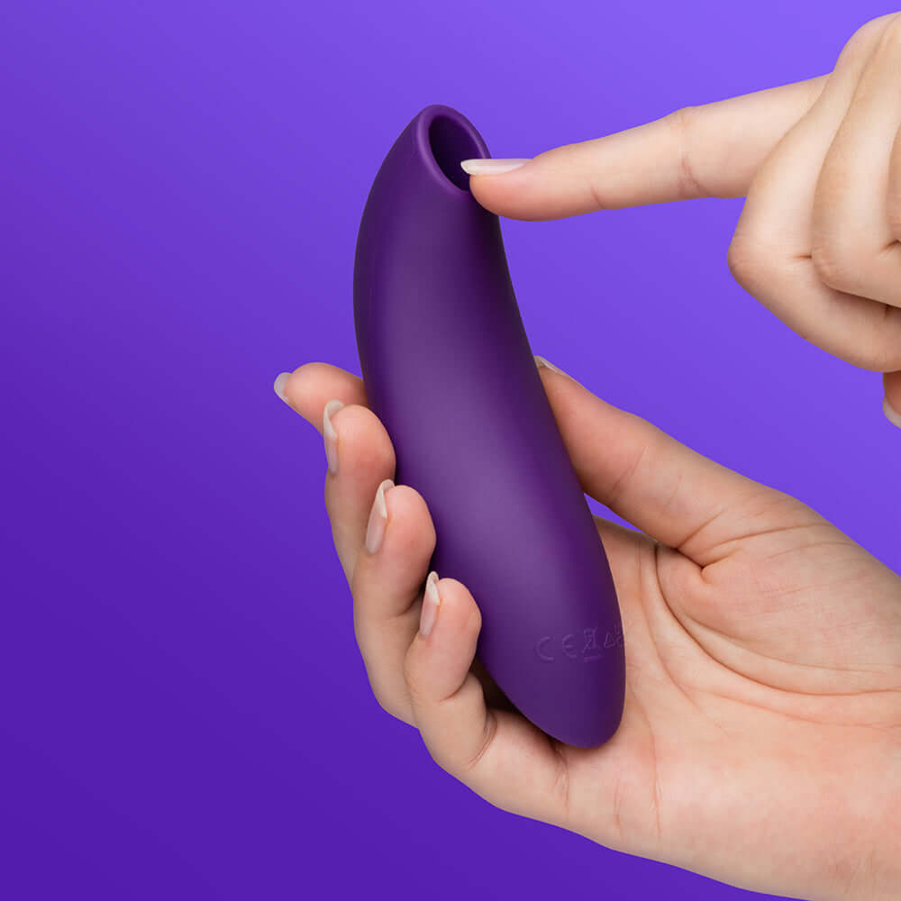 We-Vibe Melt 2 Pleasure Air Clitoral Stimulator Purple held in hand, showcasing its ergonomic design.