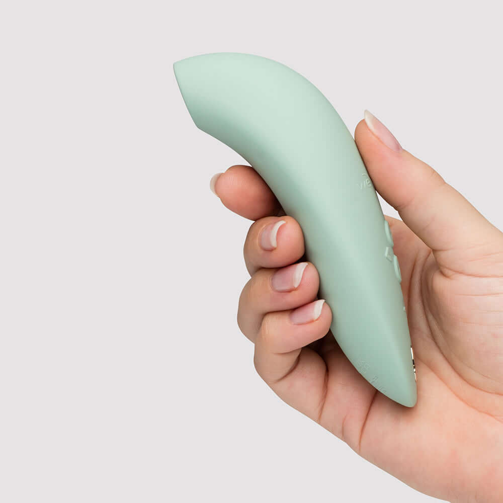 We-Vibe Melt 2 Pleasure Air Clitoral Stimulator Sage held in hand, featuring sleek design for partner-friendly use.
