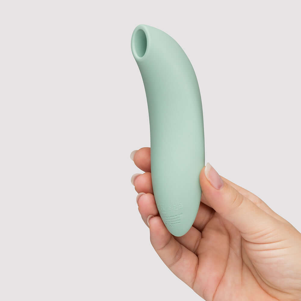 We-Vibe Melt 2 Pleasure Air Clitoral Stimulator Sage held in hand, featuring a sleek design and soft silicone.