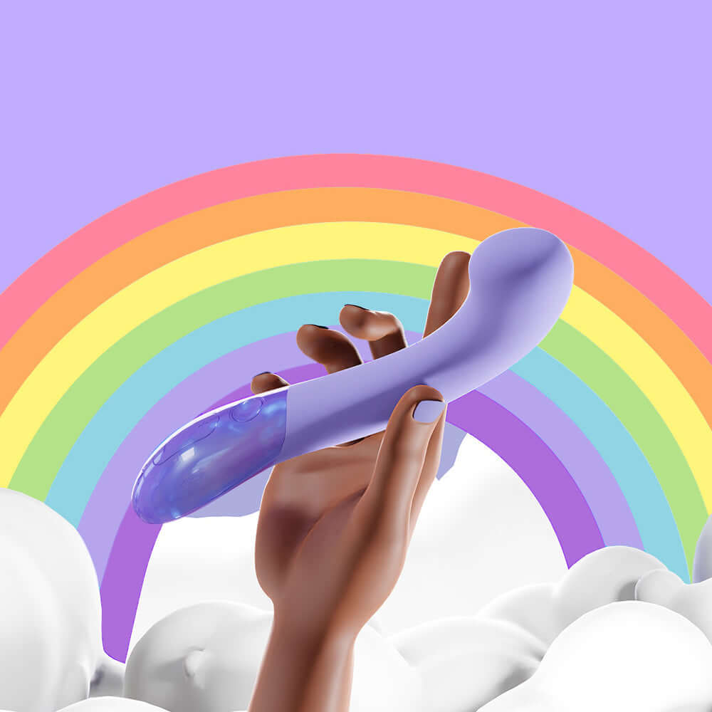 A hand holding the Biird Gii Glow Massager Lilac against a colorful rainbow background.