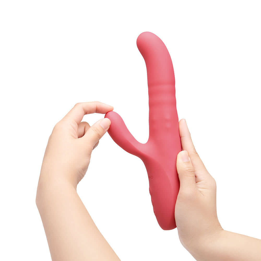 Hands holding the Le Wand Thrust Rabbit Vibrator showcasing its design and dual stimulation features.