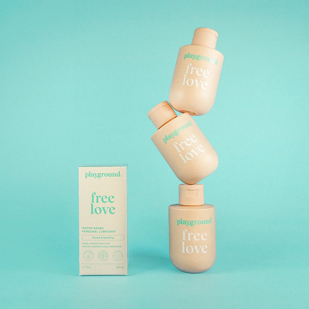 Playground Free Love Water-Based Personal Lubricant 3.7 Oz product packaging against a light blue background.