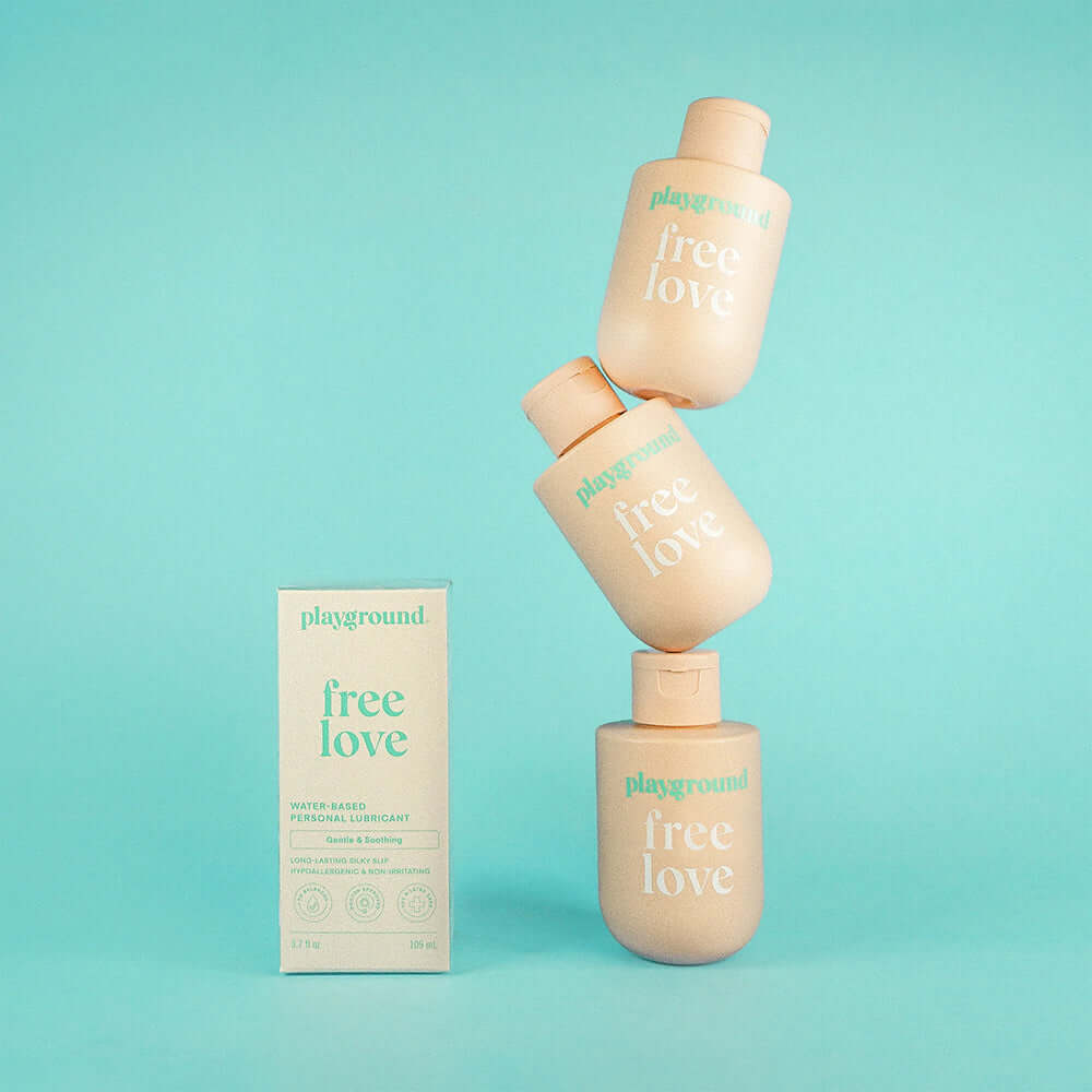 Playground Free Love Water-Based Personal Lubricant 3.7 Oz product packaging against a light blue background.