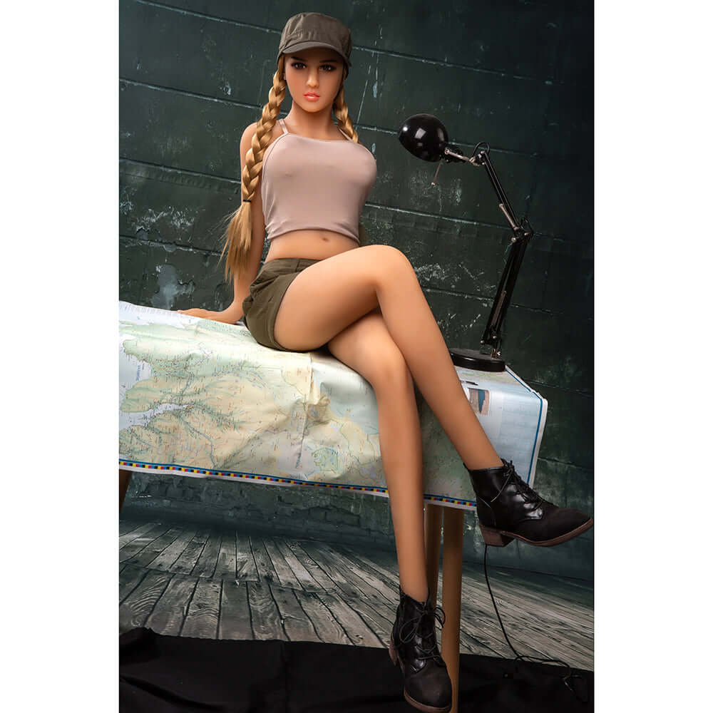 Savage Me Dreamgirl Lifelike Doll Brandy with braided hair and casual outfit sitting at a table.