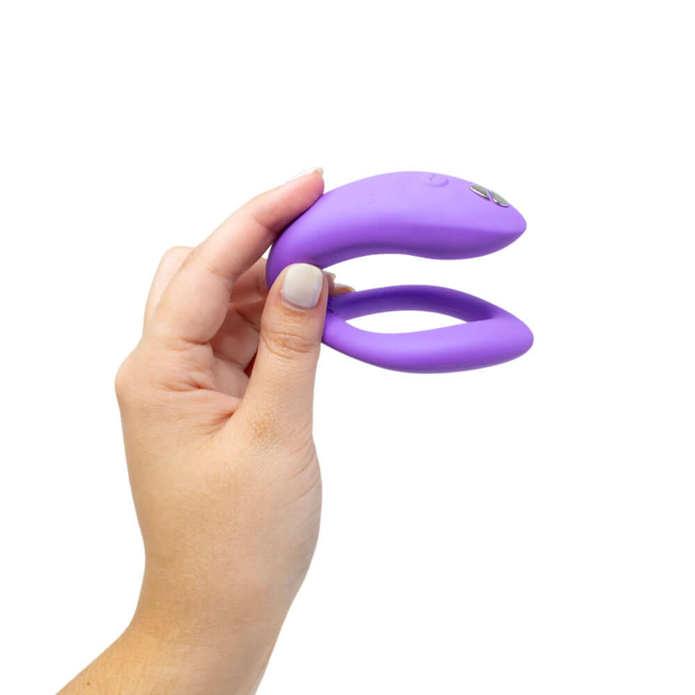 We-Vibe Sync O Vibrator Light Purple held in a hand, showcasing its innovative design for couples' pleasure.