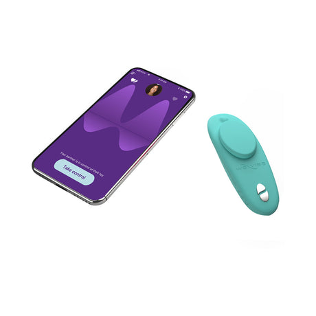 We-Vibe Moxie Plus Wearable Clitoral Vibrator Teal next to smartphone app for remote control.
