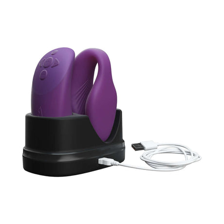 We-Vibe Chorus Couples Vibrator Purple charging in its dock with USB cable.