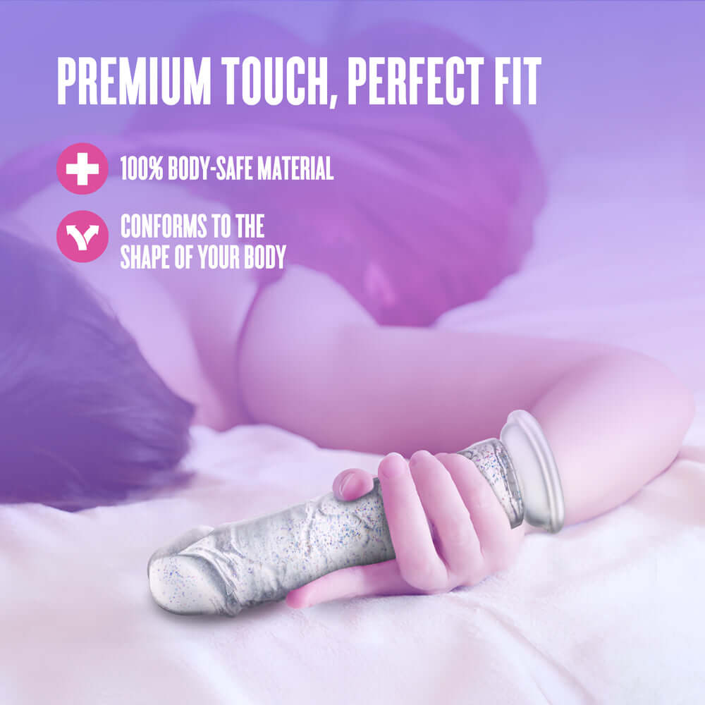 Naturally Yours Gala Sparkling Dildo Clear on a bed, showcasing its body-safe material and perfect fit for comfort.