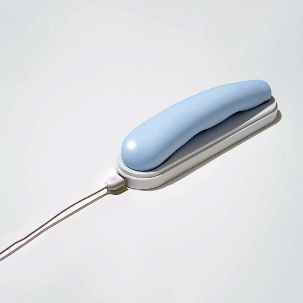 iroha tsuki MINAMO Massager in soft blue color with charging cable on a white background.