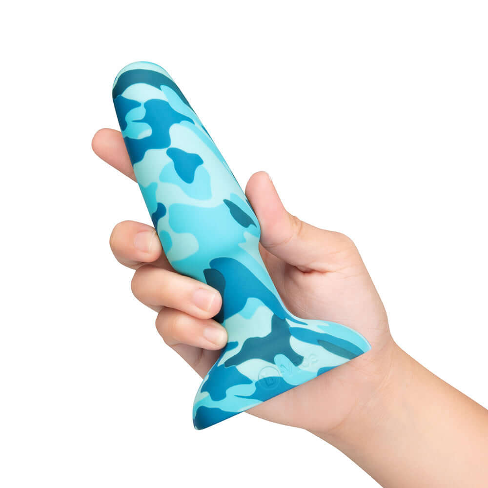 A hand holding the b-Vibe Rimming Butt Plug 2 Camo, showcasing its vibrant camo design.