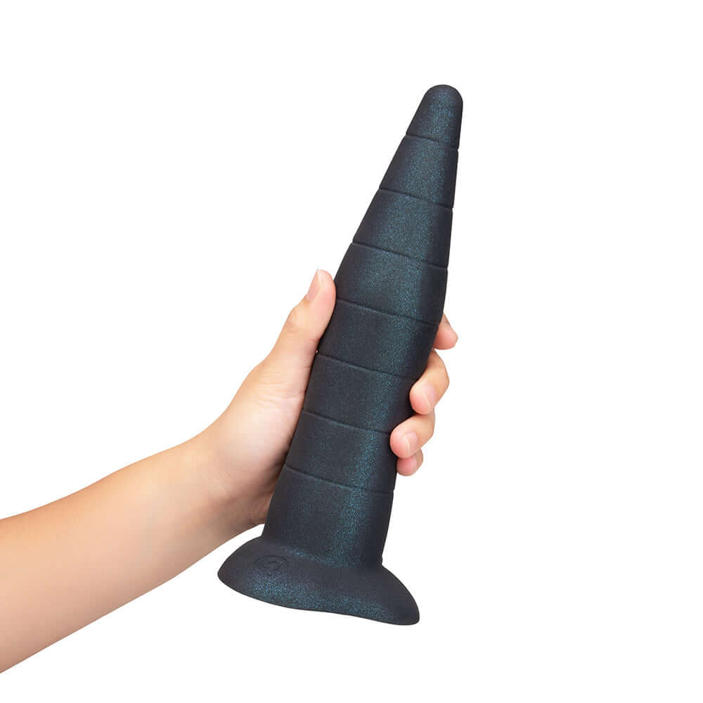 b-Vibe Fisting Anal Trainer held in hand, featuring a tapered cone shape with graduated girth for anal training.