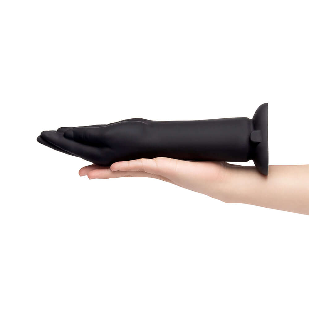 b-Vibe Vibrating Silicone Fisting Dildo held in hand showcasing its sleek design and size.