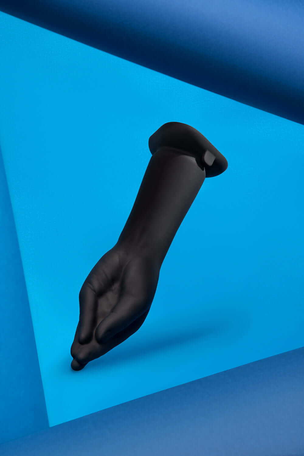 b-Vibe Vibrating Silicone Fisting Dildo displayed against a blue background, highlighting its unique design and texture.