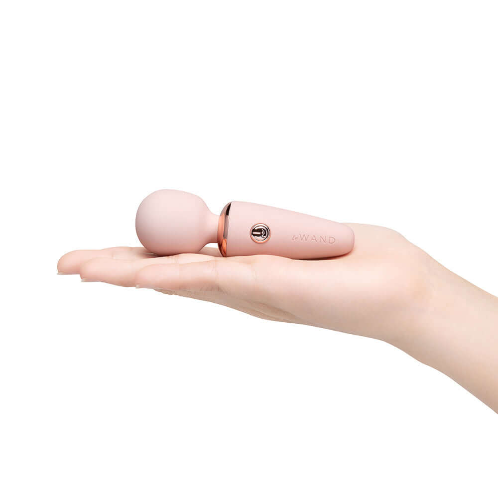 Le Wand Mini Micro Wand Rose Gold held in a hand, showcasing its compact design and elegant silhouette.