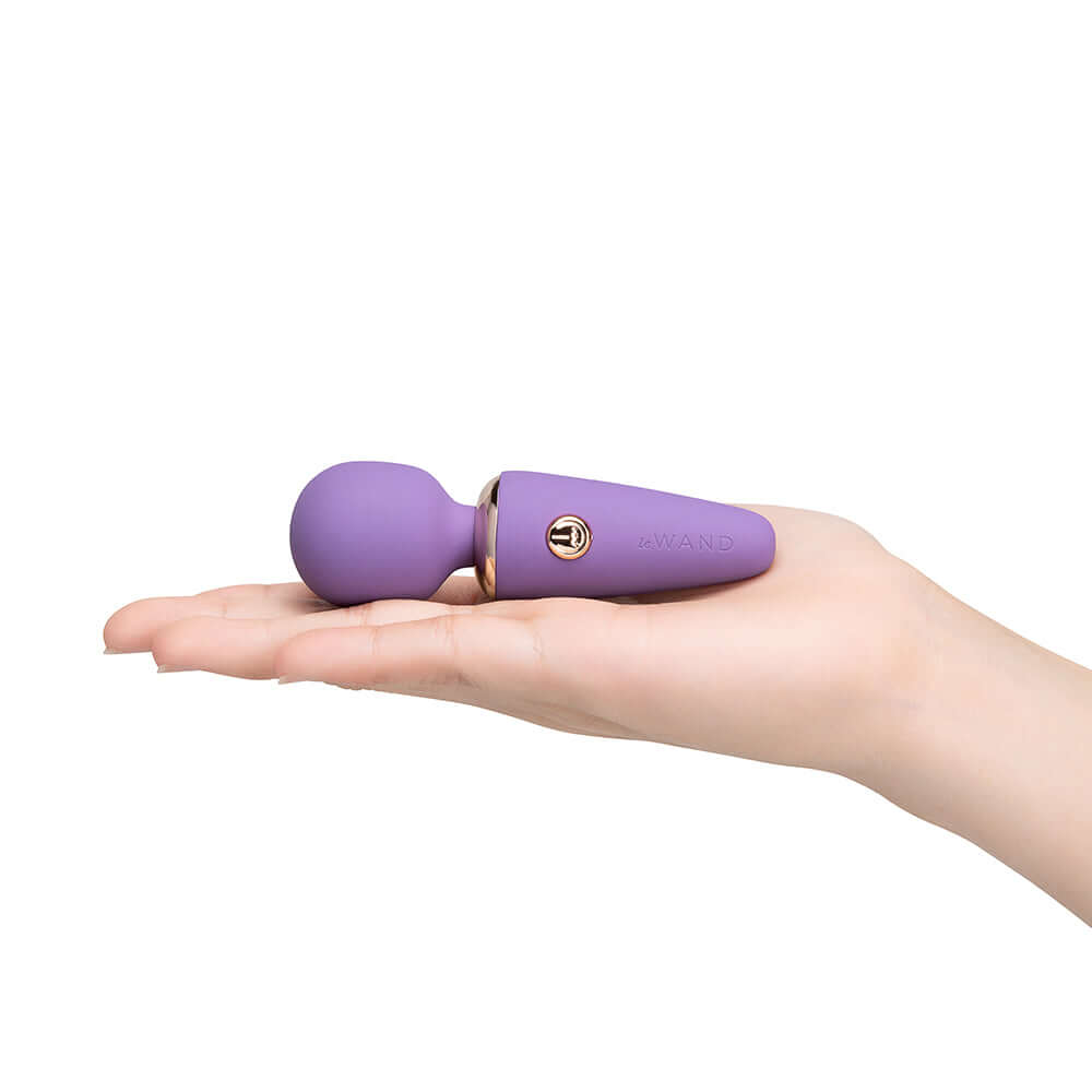 Le Wand Mini Micro Wand Massager Violet held in hand, sleek design for travel-friendly powerful vibrations.