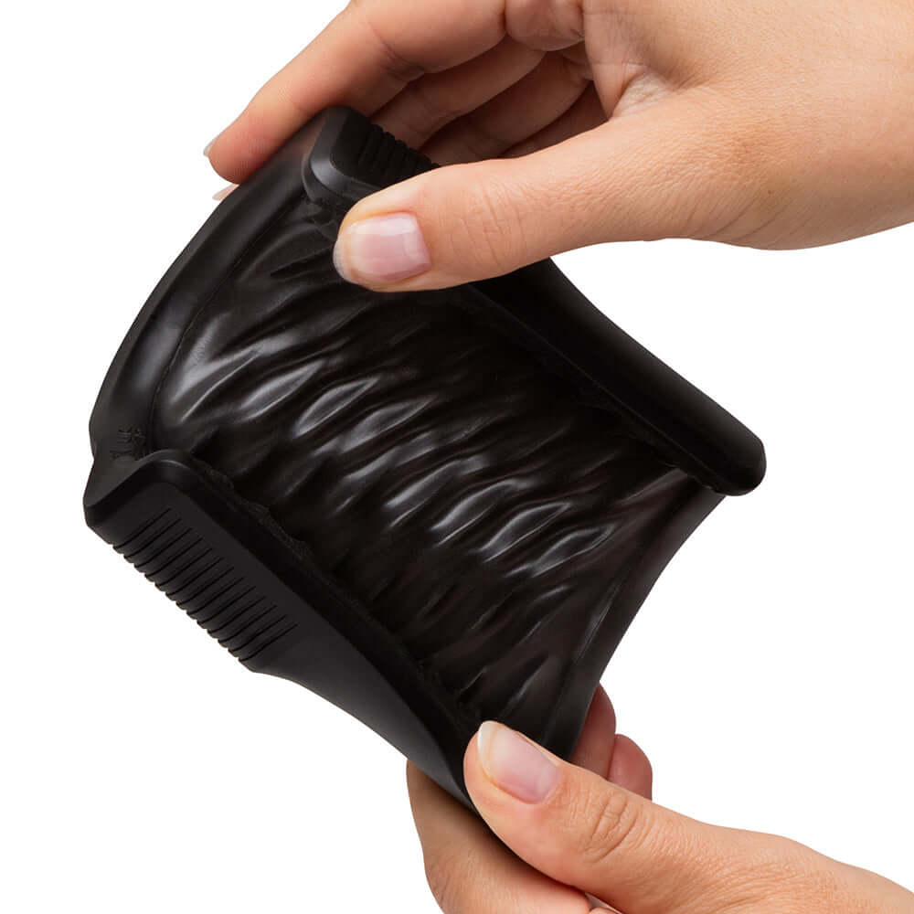 Arcwave Zing Vibrating Half Sleeve Dual Motor Masturbator held in hands, showcasing flexible design and textured surface.