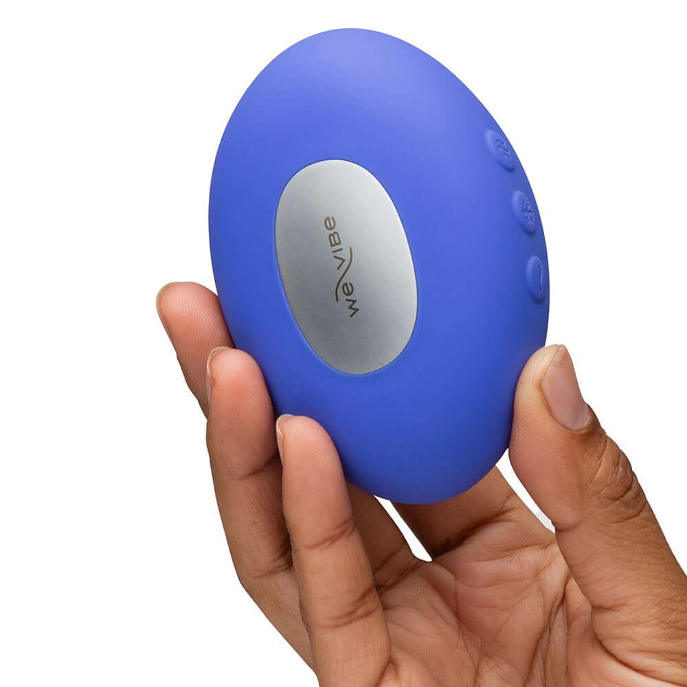 We-Vibe Temp Clitoral Massager Lavender Blue held in hand showcasing its sleek design and ergonomic shape.