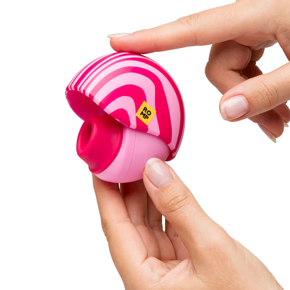 ROMP Spin Travel Rechargeable Clitoral Stimulator held in hand, showcasing its compact and playful design.