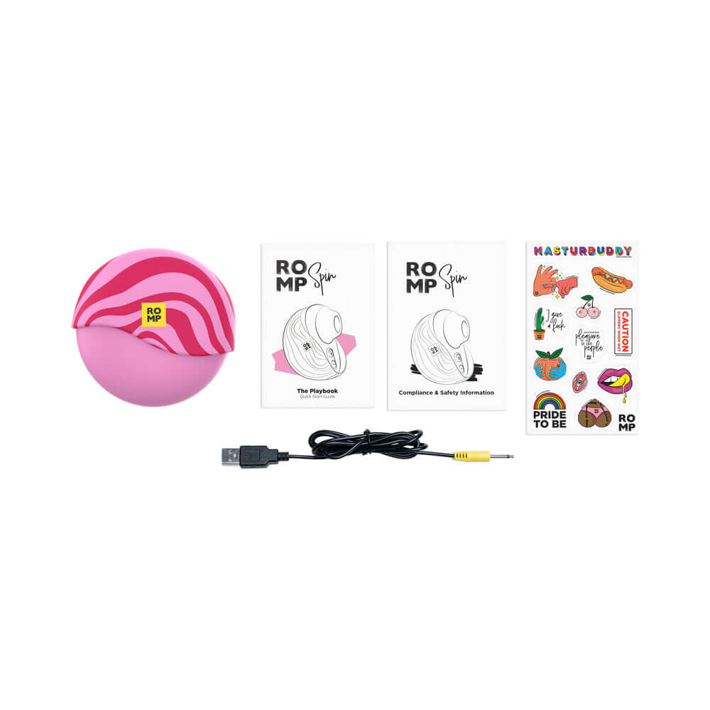 Image of the ROMP Spin Travel Rechargeable Clitoral Stimulator, USB cable, instruction booklet, and stickers.