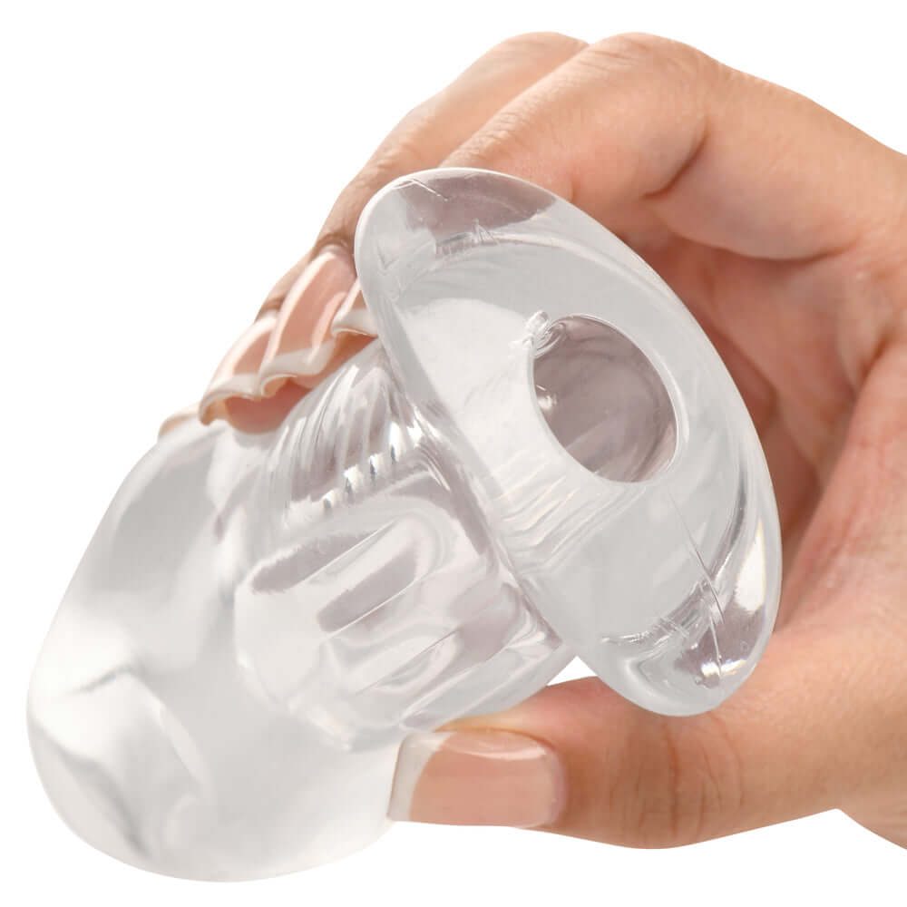 Master Series Dicked Clear Hollow Anal Plug Medium held in hand showing transparent design and hollow interior.