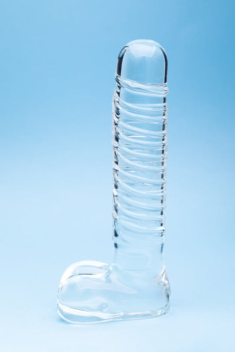 Clarity Seraphic Opus Glass Dildo displayed on a blue background, showcasing its elegant design and craftsmanship.