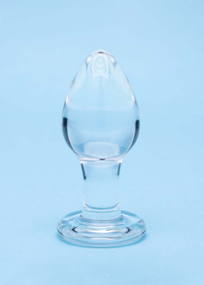 Clarity Utopian Trinity Glass Plug Set - clear glass butt plug with a refined design on a blue background.