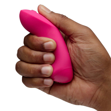 We-Vibe Chorus Pro Couples Massager Electric Pink held in hand, showcasing its ergonomic design and vibrant color.