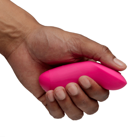 We-Vibe Chorus Pro Couples Massager Electric Pink held in hand, showcasing its ergonomic design and vibrant color.