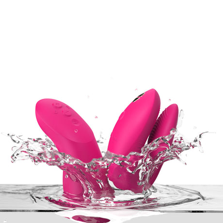We-Vibe Chorus Pro Couples Massager Electric Pink splashing in water, showcasing vibrant color and design.