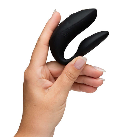 We-Vibe Chorus Couples Vibrator with Remote Control Black held in hand, showcasing its sleek design and functionality.