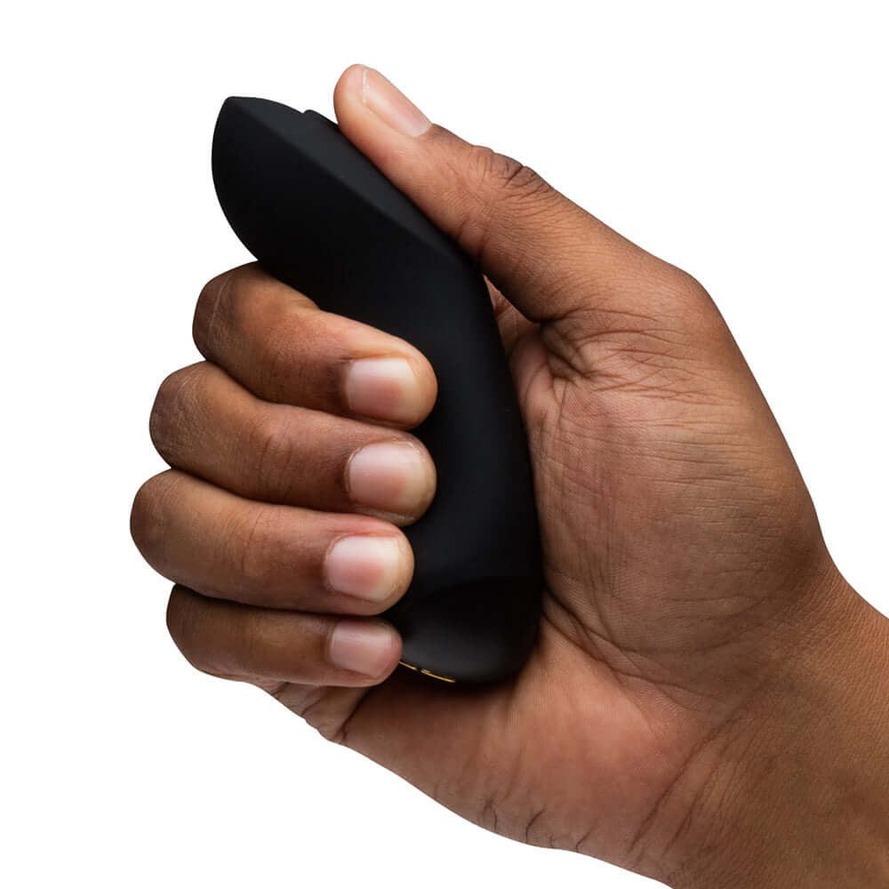 Person holding We-Vibe Chorus Couples Vibrator with Remote Control Black, showcasing its sleek design and ergonomic grip.