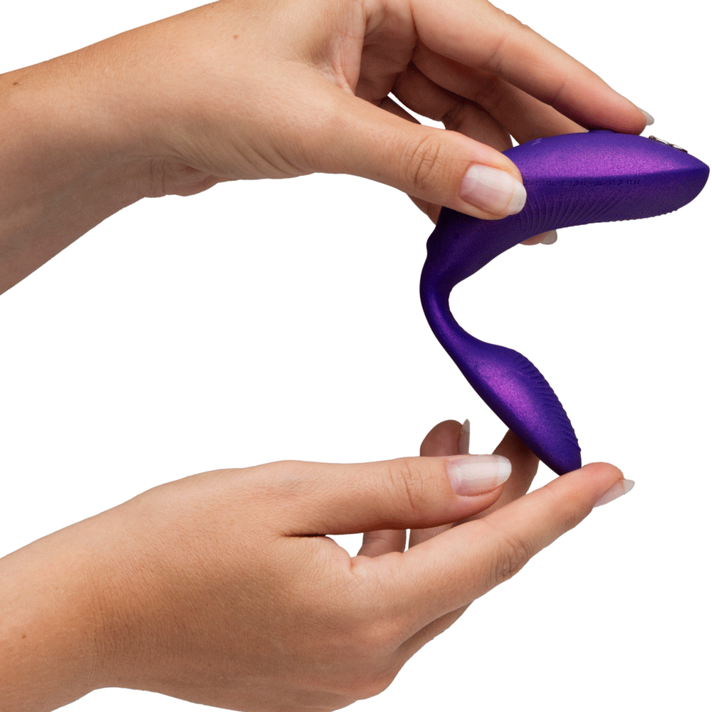 Hands holding the We-Vibe Chorus Pro Cosmic Purple couples' vibrator, showcasing its ergonomic design.