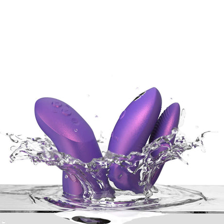 We-Vibe Chorus Pro Cosmic Purple vibrators splashing in water, showcasing innovation and design for couples.