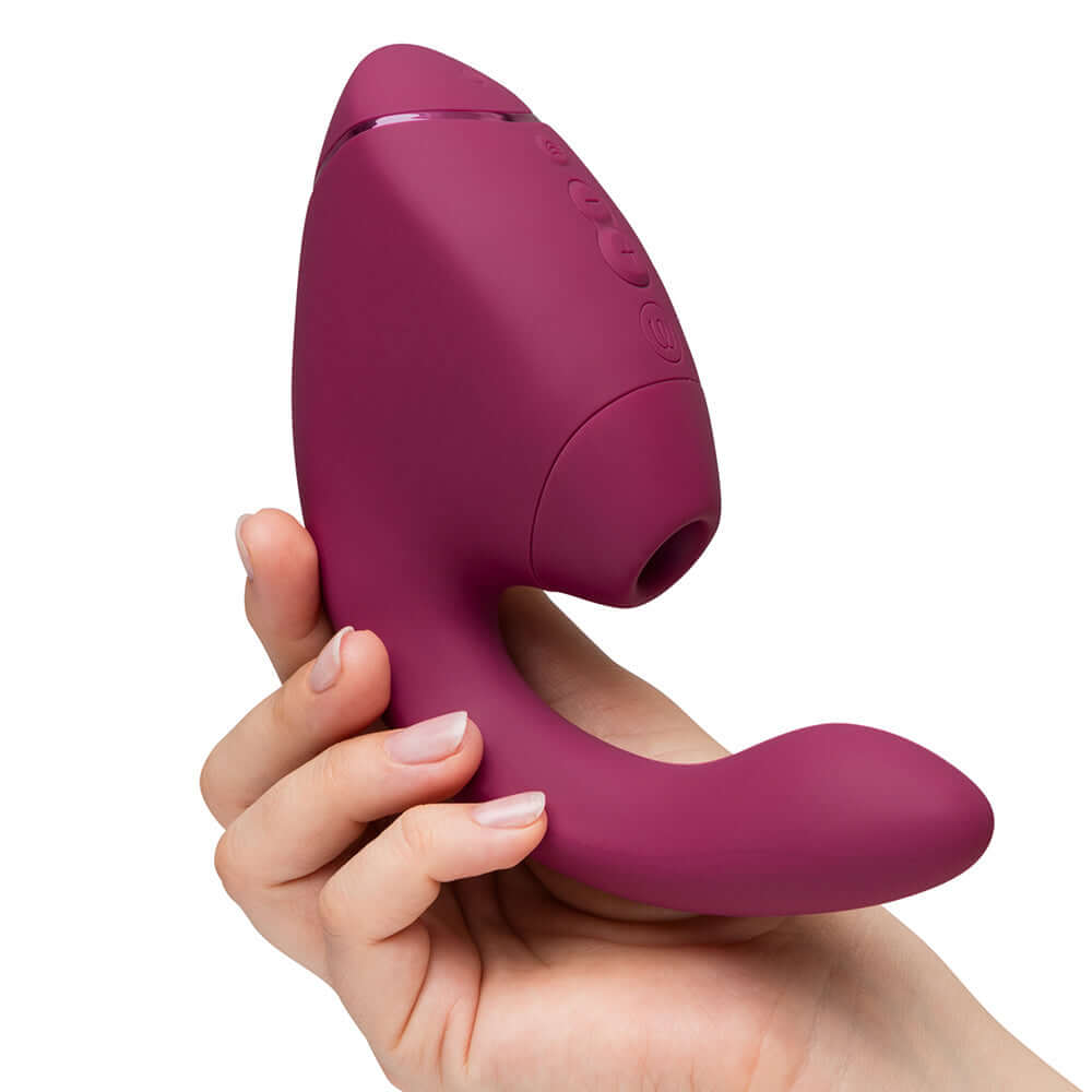 Womanizer Next Duo Massager Dusky Pink held in a hand, showcasing its ergonomic design for dual stimulation.