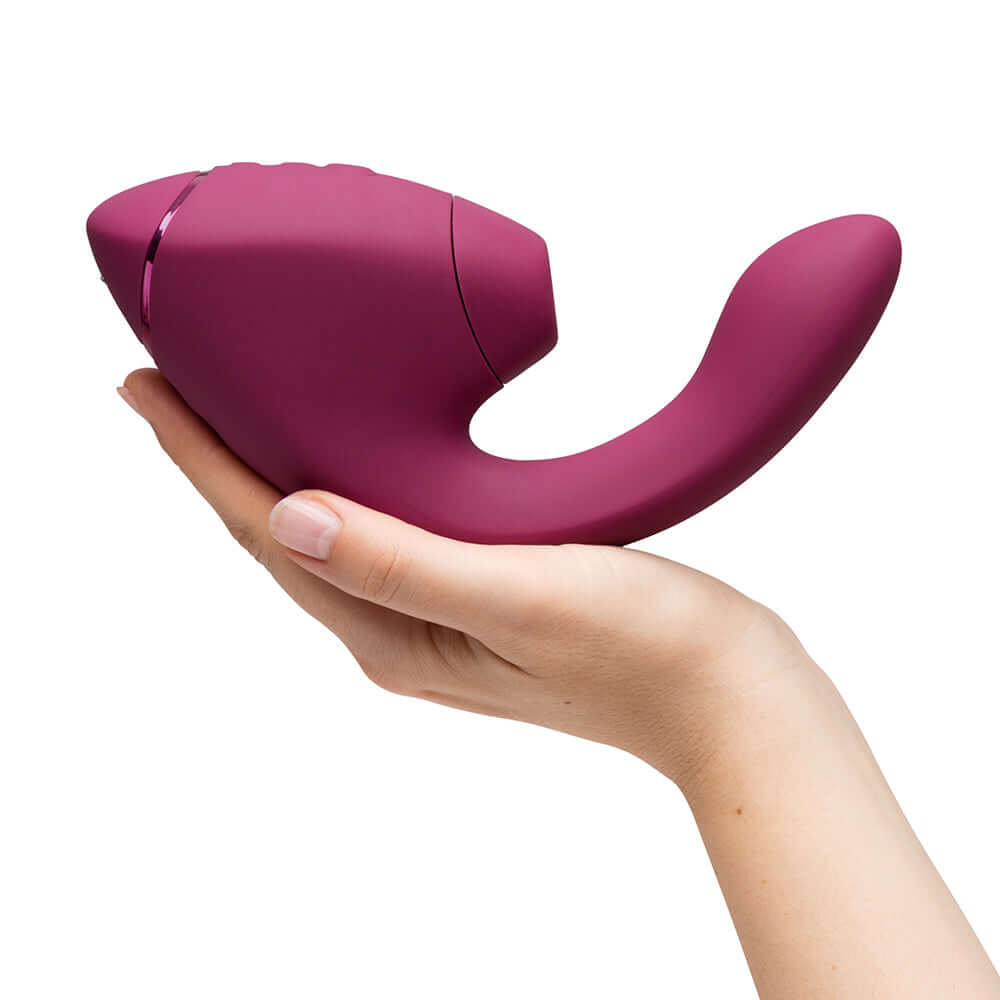Womanizer Next Duo Massager Dusky Pink held in hand, showcasing its ergonomic design and dual stimulation features.