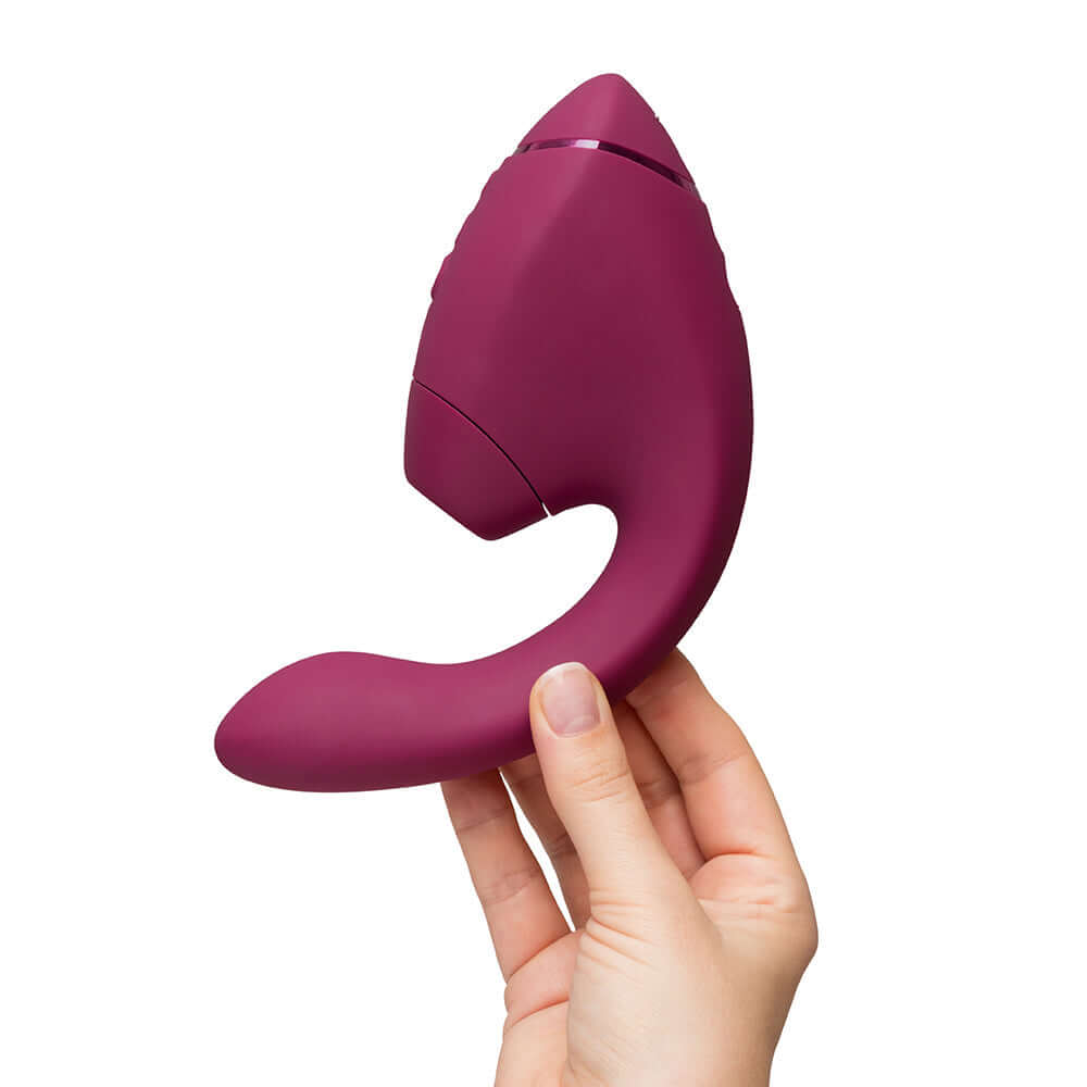 Womanizer Next Duo Massager Dusky Pink held in hand, showcasing its unique design for dual stimulation.