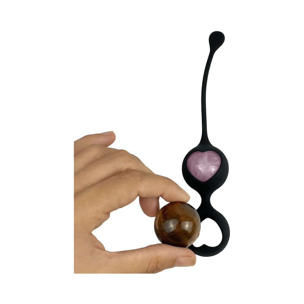 Adrien Lastic Harmony Stones Kegel and Chakra Set, showcasing a hand holding a natural stone and the unique Kegel device.