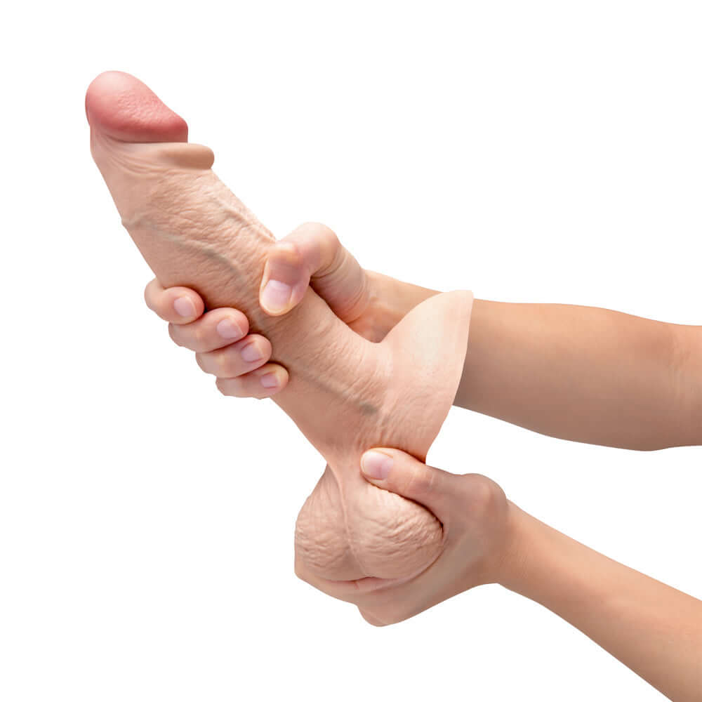 b-Vibe Slipskin Realistic Silicone Dildo 8 inch Girthy Cream held in hand, showcasing its lifelike silicone texture and flexibility.