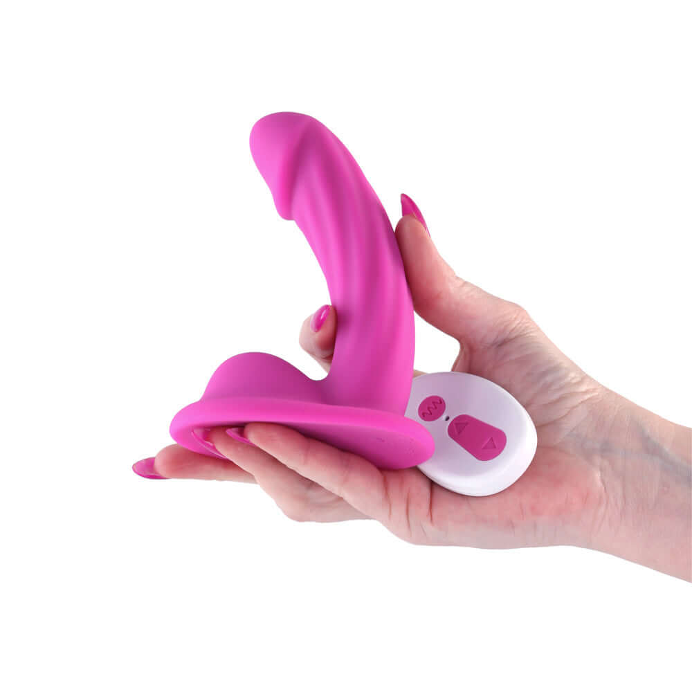 Colours Curve Vibrating 5 inch Dildo Pink in hand with remote control, showcasing its ergonomic design and textured shaft.