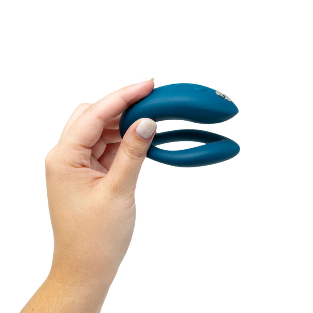 We-Vibe Sync O Remote Control Couples Vibrator Velvet Green held in a hand, showcasing its ergonomic design.