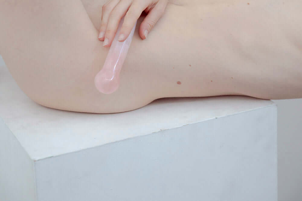 Person using Chakrubs Heart Curve Rose Quartz Wand on their skin for sensual healing and energy work.
