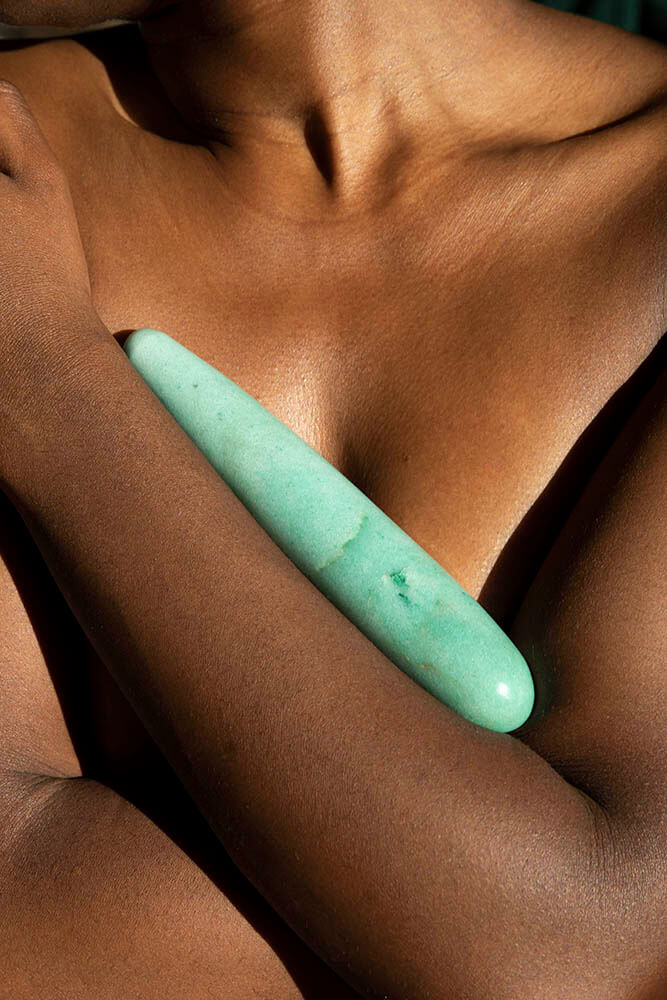 Chakrubs Indian Jade Original Green Aventurine Wand embraced against skin, showcasing its natural beauty and healing properties.