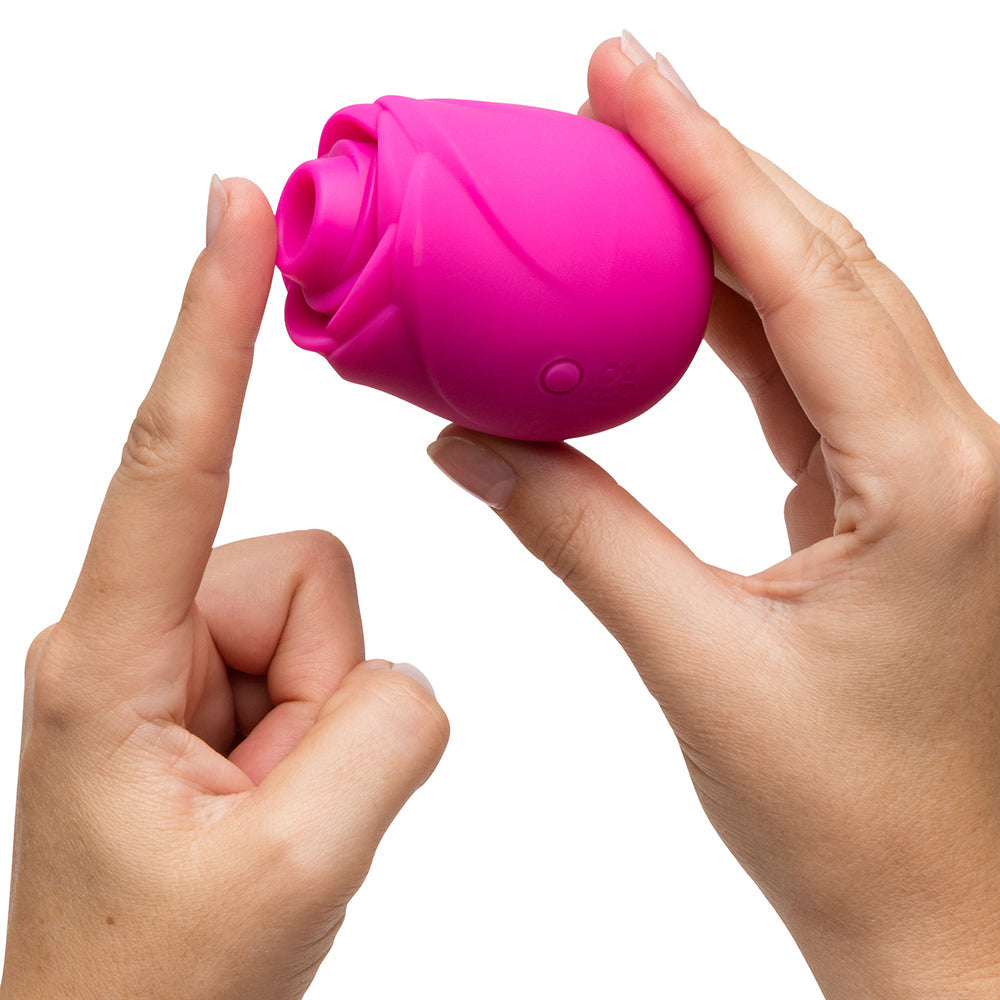 A person holding the Romp Rose 2.0 Air Suction Stimulator, designed like a pink rose.