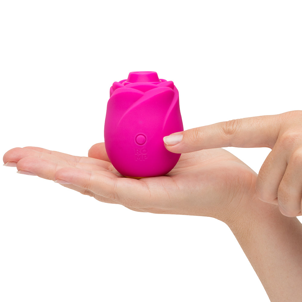 Romp Rose 2.0 Air Suction Stimulator held in a hand, showcasing its elegant rose-inspired design and compact size.