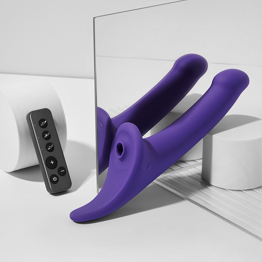 Strap-on-me Multi Orgasm Dildo Medium Purple with remote on display in modern setting.
