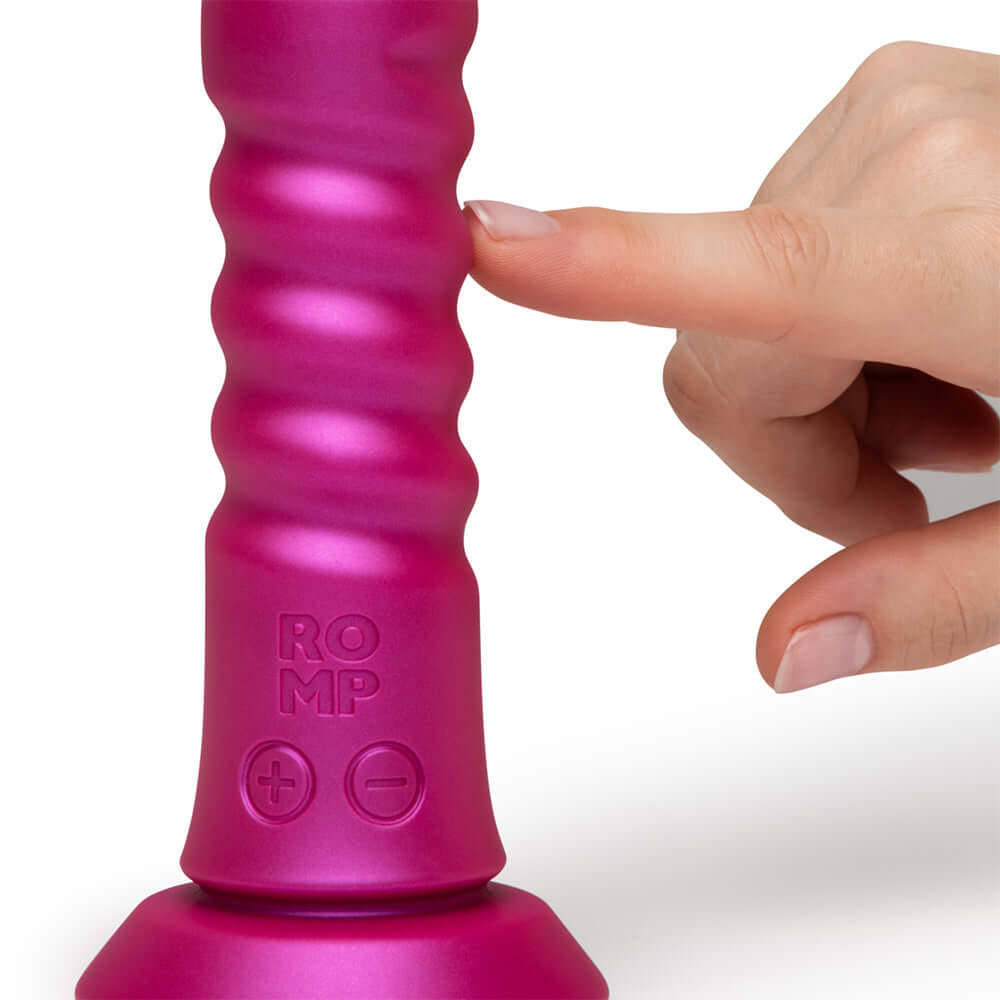 Close-up of Romp Jiggle Thrusting Vibrator Pink with user pressing buttons for customizable motion.